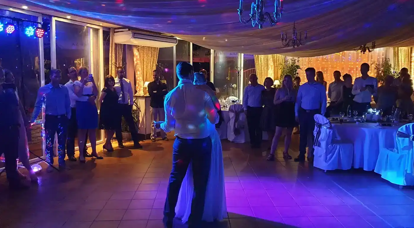 Esküvői nyitótánc a násznép előtt, DJ-fényekkel